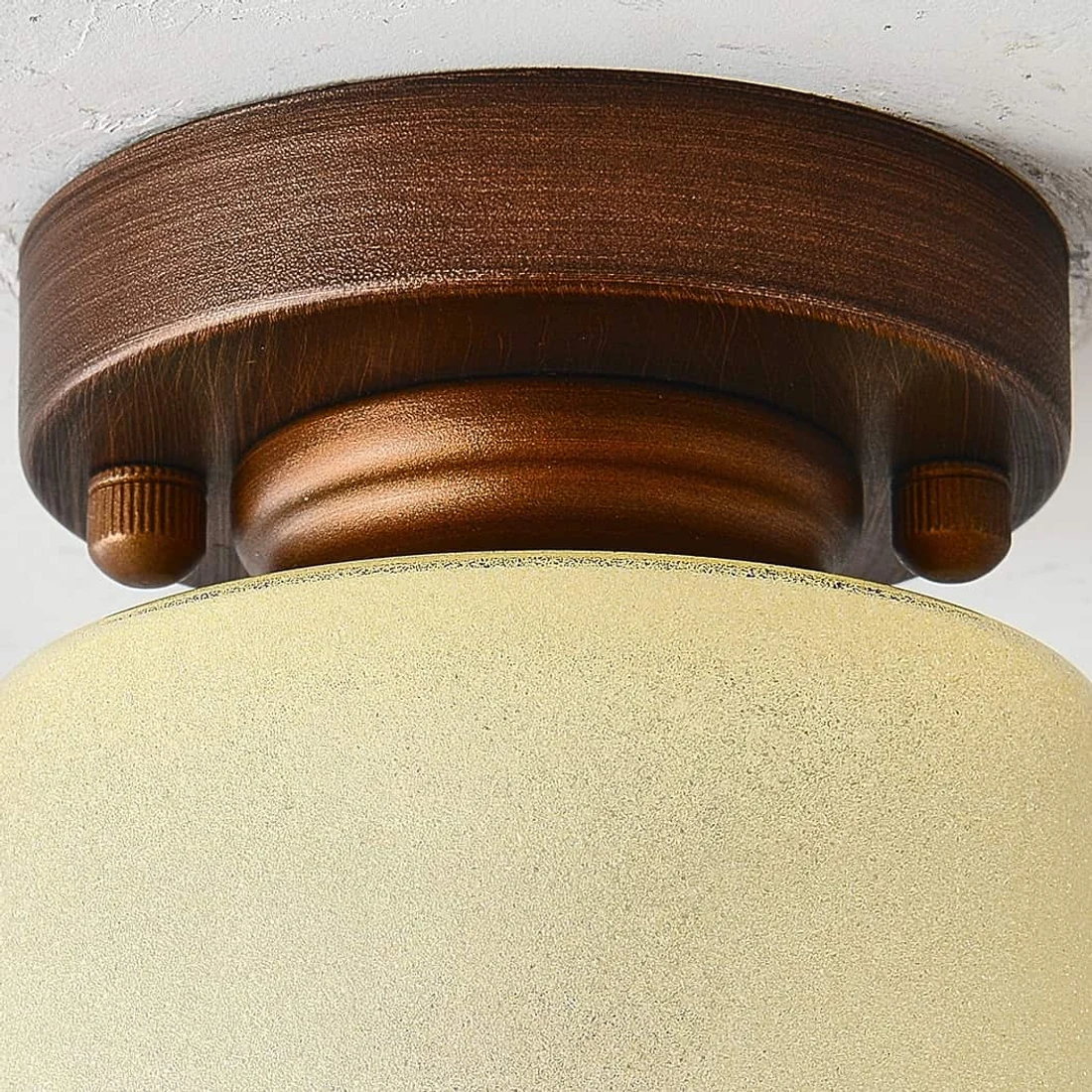 Close detail of brushed bronze ceiling mount hardware